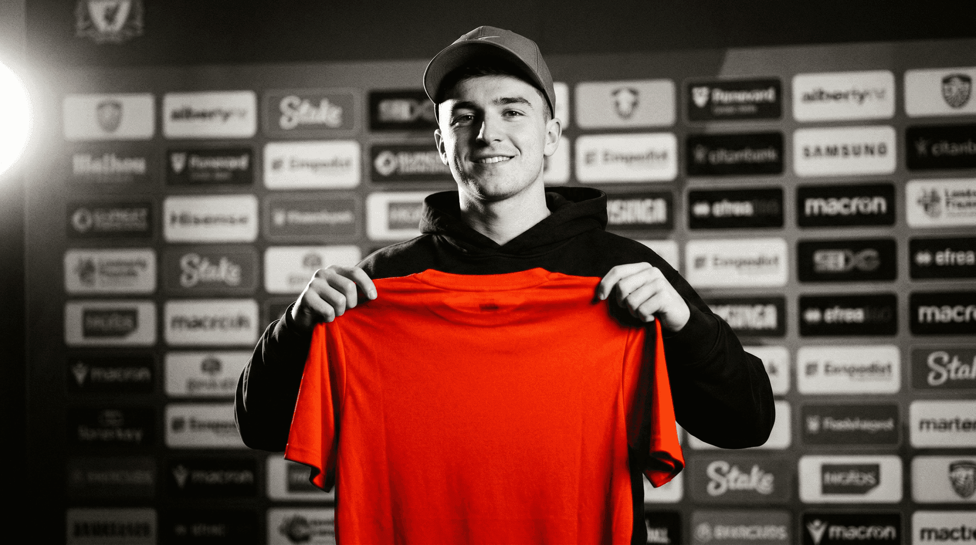 Male fan holding up a red club shirt